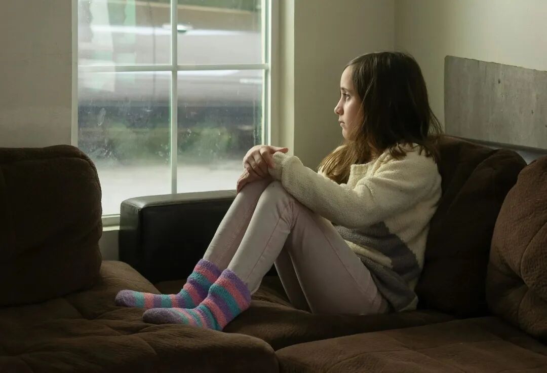 woman in white long sleeve shirt sitting on black couch